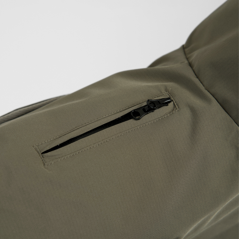 Close-up of the zip pocket on the olive green rain coat