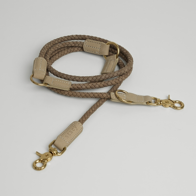 Kaia braided dog leash in taupe leather, coiled with brass hooks