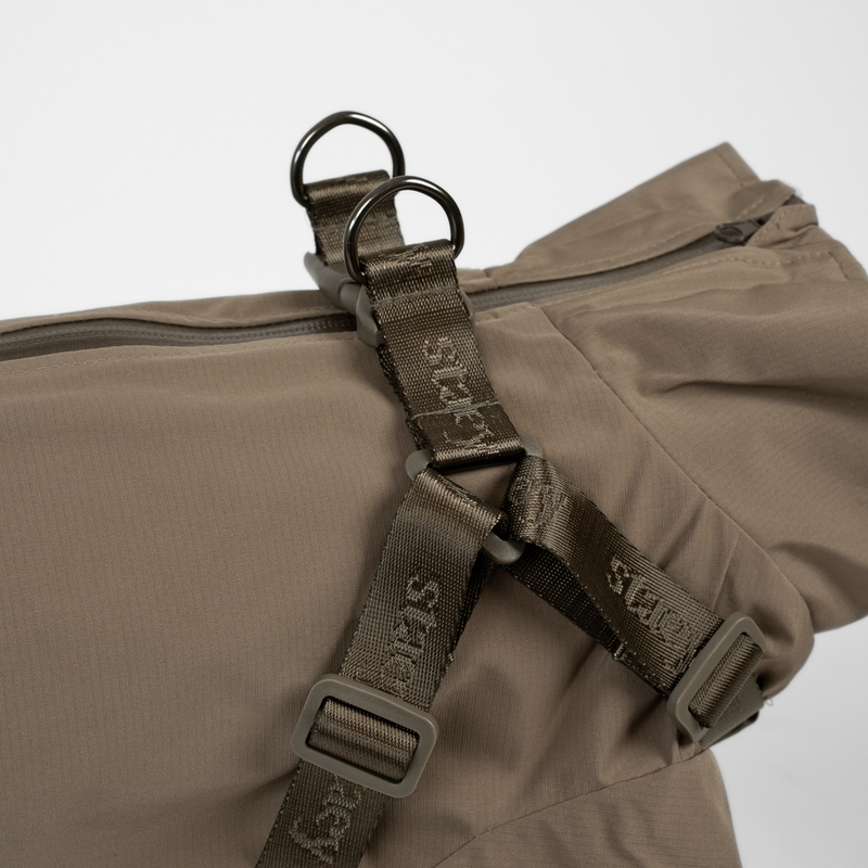Close-up of the harness straps and D-ring on the taupe rain coat